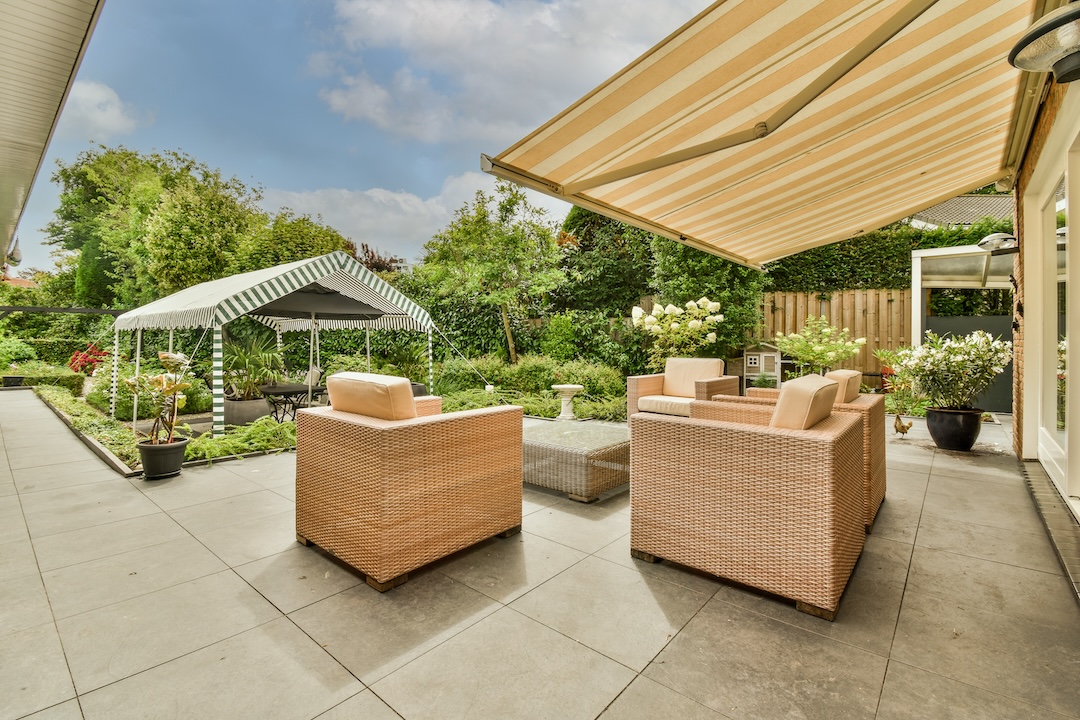 Neat powerful patio with sitting area and small garden near wooden fence